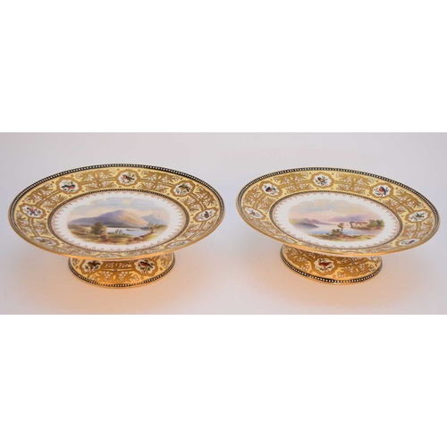 52 - A pair of Coalport low pedestal dessert comport dishes, circa 1880, painted with named views of Dart... 