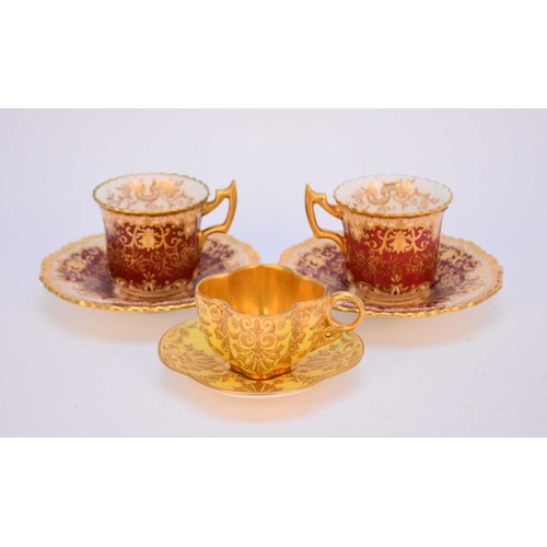 69 - Three Coalport gilt-raised cups and saucers, late 19th and early 20th century, comprising a pair of ... 