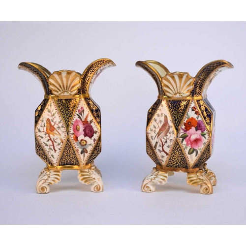 98 - A pair of Coalport faceted vases, circa 1815, raised on moulded feet, painted with diamond-shape pan... 