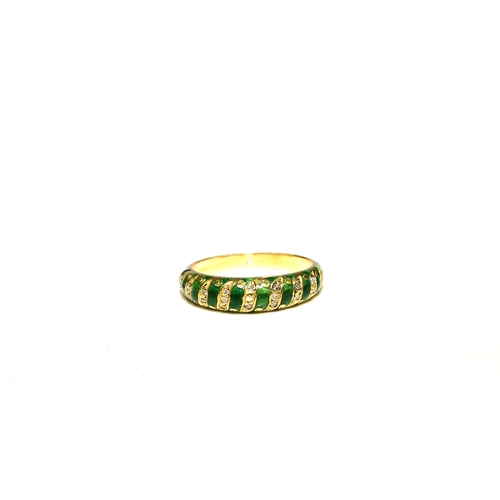 100 - A French diamond and green enamel ring, the tapering band set with graduated diamond set scrolls to ... 