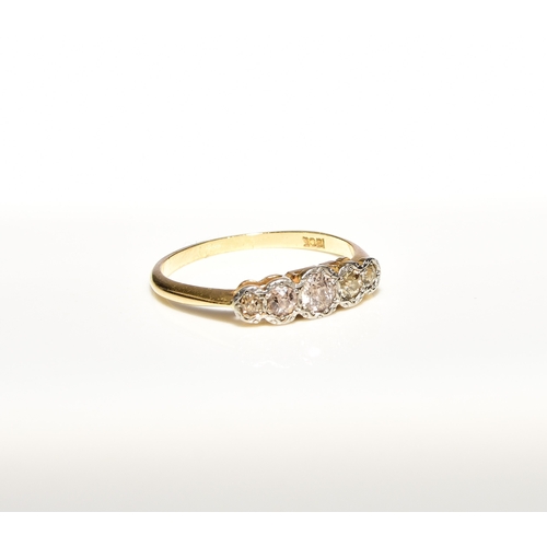 102 - A graduated five stone diamond ring, the old cut diamonds illusion set in white metal to yellow meta... 