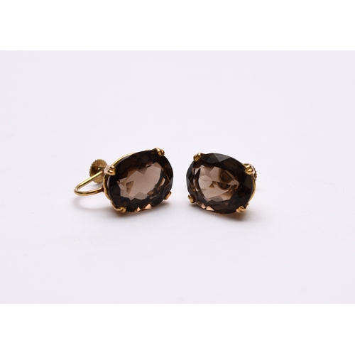 121 - A pair of smoky quartz earrings, each claw set in yellow metal with screw fittings, stamped '585', w... 