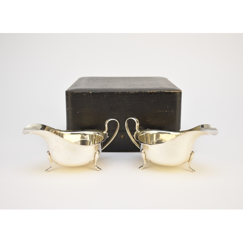 7 - A cased pair of silver cream jugs, Barker Brothers Silver Ltd, Birmingham 1938, each of typical form... 