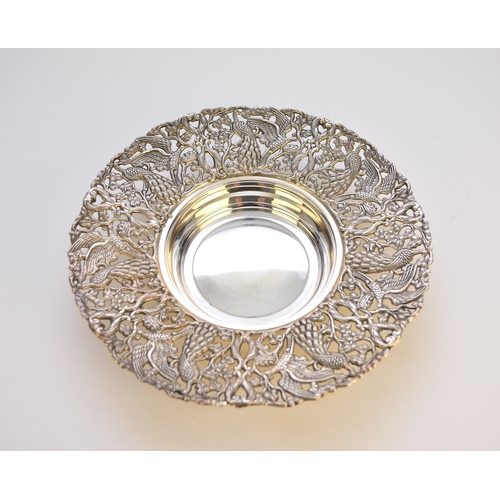 79 - A white metal dish, of circular form with wide pierced border formed as peacocks and birds amongst s... 