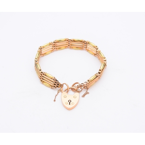 84 - A yellow and rose metal five bar gate link bracelet, with heart shaped padlock clasp stamped '15', w... 