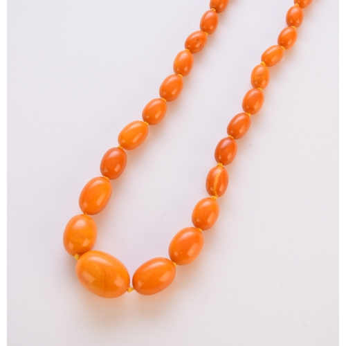 93 - A graduated oval amber bead necklace, comprising forty-one oval amber beads graduating from approx 2... 