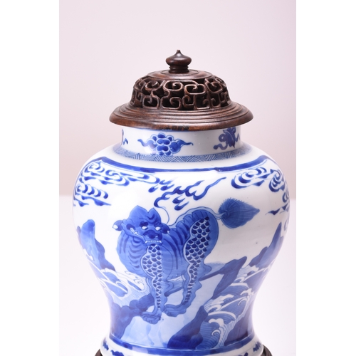 27 - A Chinese blue and white jar with wood cover and stand, Kangxi Of baluster form and decorated with p... 
