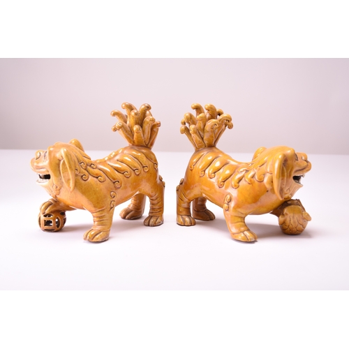 43 - A pair of Chinese yellow sancai-glazed figures of guardian lions Early 20th century The male with hi... 