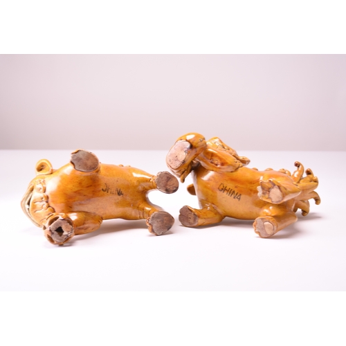43 - A pair of Chinese yellow sancai-glazed figures of guardian lions Early 20th century The male with hi... 