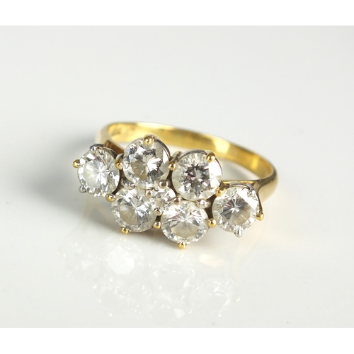 105 - An 18ct gold seven stone diamond dress ring, designed a central raised brilliant cut diamond claw se... 