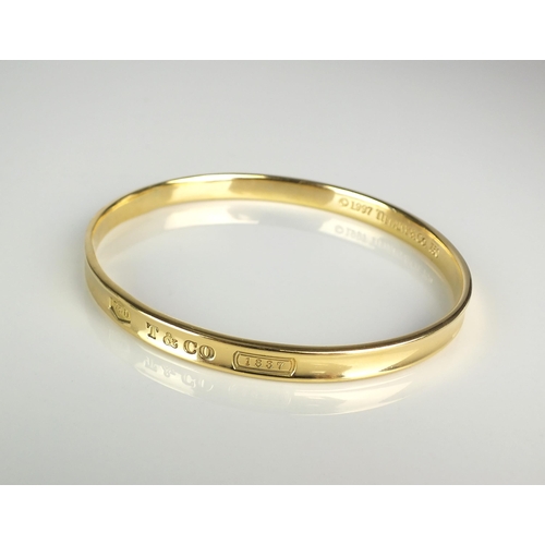 110 - A Tiffany & Co 18ct yellow gold bangle, the outer bangle inscribed '750 T & CO 1837', the inner bang... 