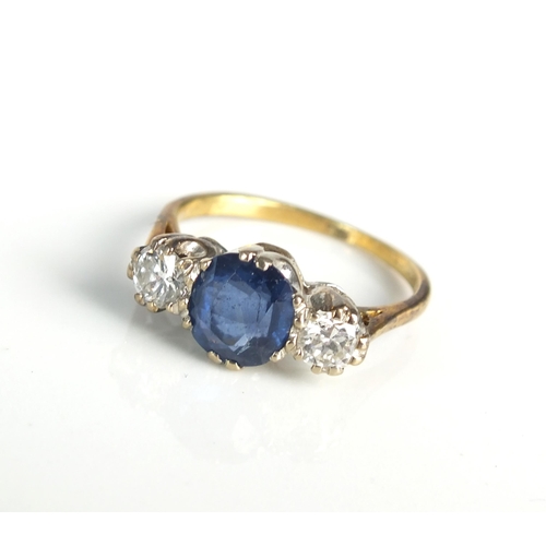 113 - An 18ct gold three stone sapphire and diamond ring, designed as a central round mixed cut sapphire f... 