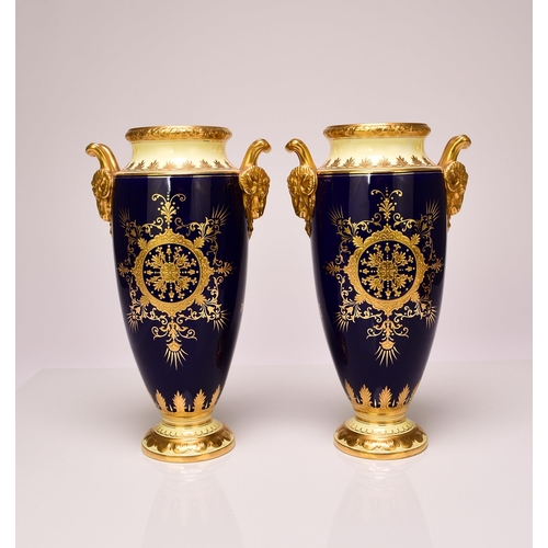 182 - A pair of Coalport vases, circa 1900-10 of tall, ovoid form, with twin rams head handles, the cobalt... 