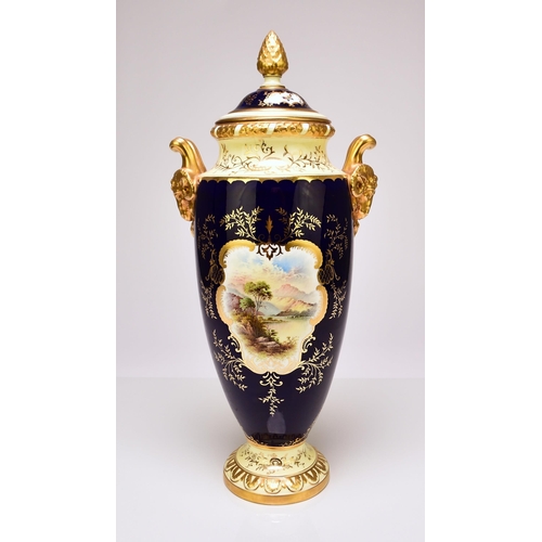 207 - A large Coalport twin-handled landscape vase and cover, circa 1910 with rams head handles, painted w... 