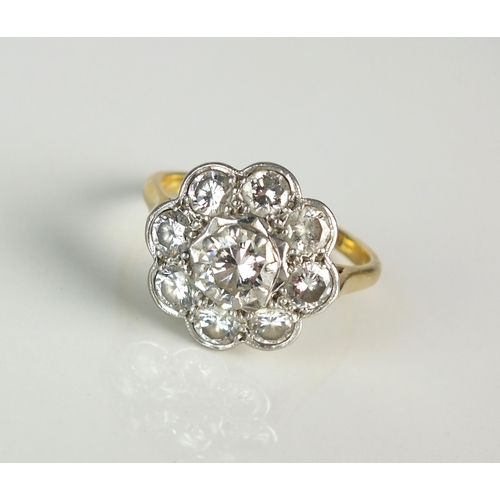 25 - A diamond floral cluster ring, designed as a central raised brilliant cut diamond claw set in white ... 