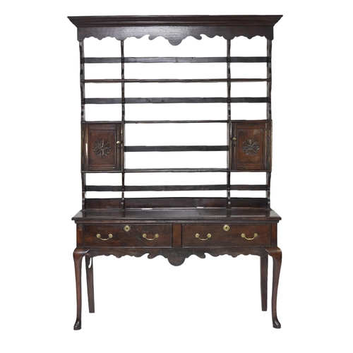 332 - An 18th century oak dresser and rack The open rack with ogee cornice and shaped apron above three sh... 