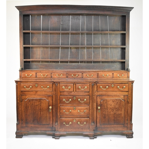 334 - A George III oak breakfront dresser and rack, North Wales The boarded rack with ogee cornice and thr... 