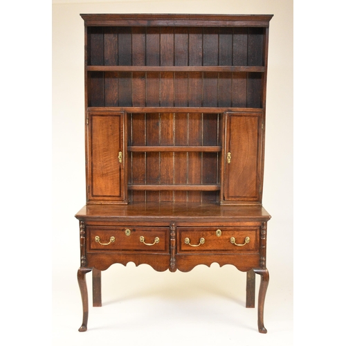 338 - A George III oak cross-banded dresser and rack The ogee cornice above four shelves, the lower flanke... 