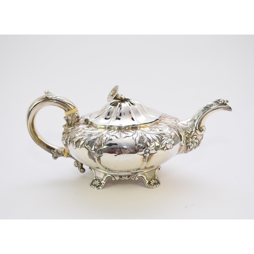 4 - A George IV silver teapot, makers mark rubbed, London 1828, of compressed melon form with embossed f... 