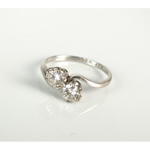 40 - A two stone diamond crossover ring, the two brilliant cut diamonds claw set in white metal to white ... 