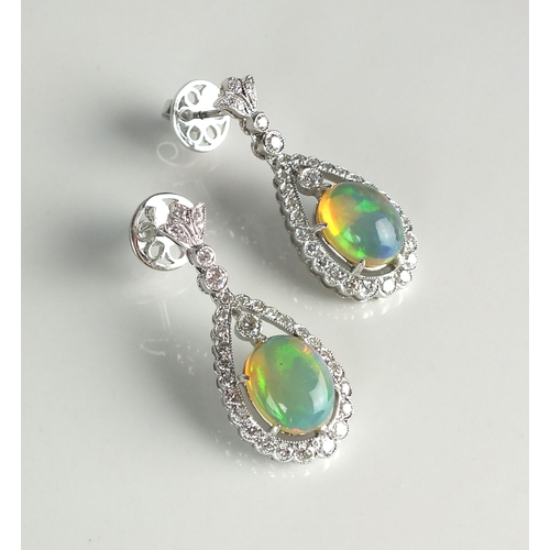 44 - A pair of 18ct white gold opal and diamond earrings, each designed as a central oval cabochon water ... 