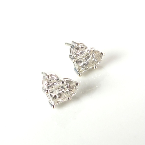 51 - A pair of 18ct white gold diamond earrings of heart form, each designed as a single square cut diamo... 