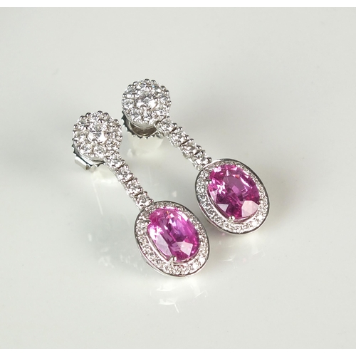 54 - A pair of 18ct white gold pink sapphire and diamond ear pendants, each designed as a single oval mix... 