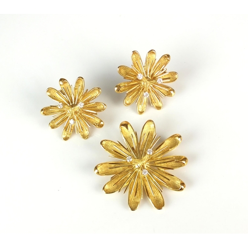 69 - A diamond set stylised flower brooch / pendant with matching earrings, each piece designed as three ... 