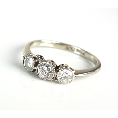 83 - A graduated three stone diamond ring, the three transition cut diamonds claw and collet set in white... 