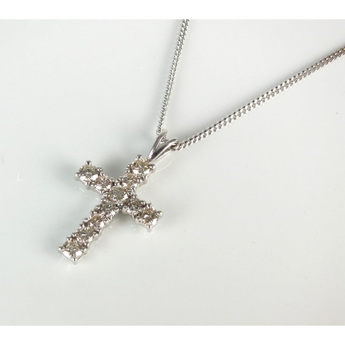 92 - An 18ct white gold diamond set crucifix pendant, the eleven brilliant cut diamonds claw set in white... 