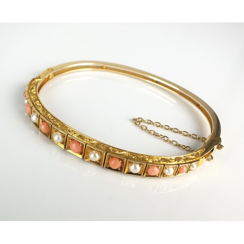 97 - A Victorian style graduated coral and split pearl hinged bangle, designed as seven circular coral ca... 