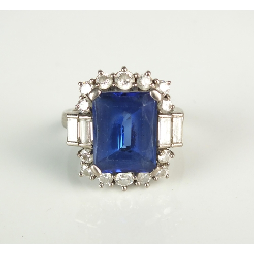 99 - A tanzanite and diamond cluster ring, designed as a large central rectangular faceted tanzanite meas... 