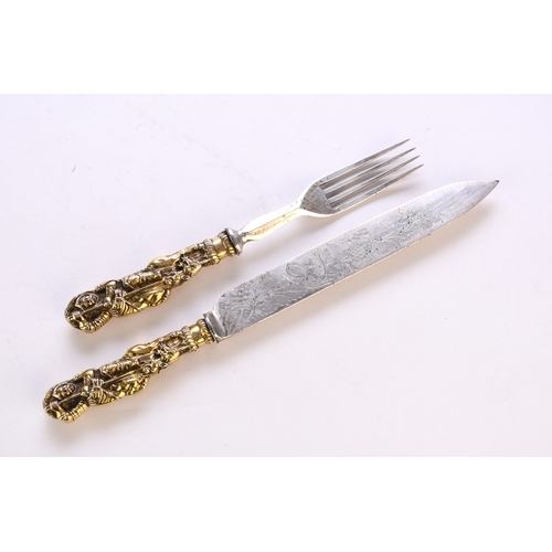 116 - A white metal and gilt metal 'George and Dragon' knife and fork, the figural gilt metal handles depi... 