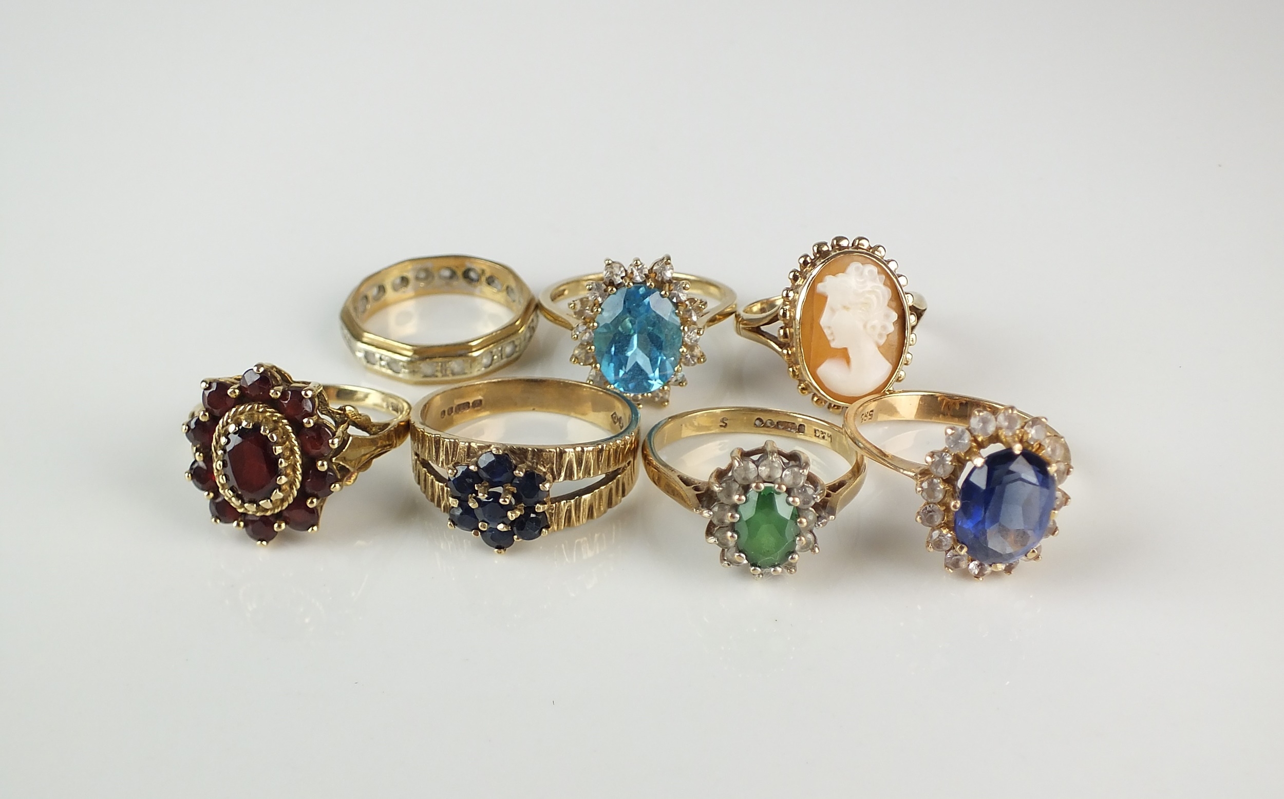 A collection of seven stone set rings, comprising; a 9ct gold garnet ...