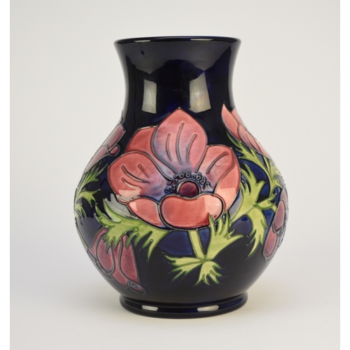 216 - A Moorcroft vase in the 'Anemone' pattern against a dark blue ground, dated 1999, 24cm high