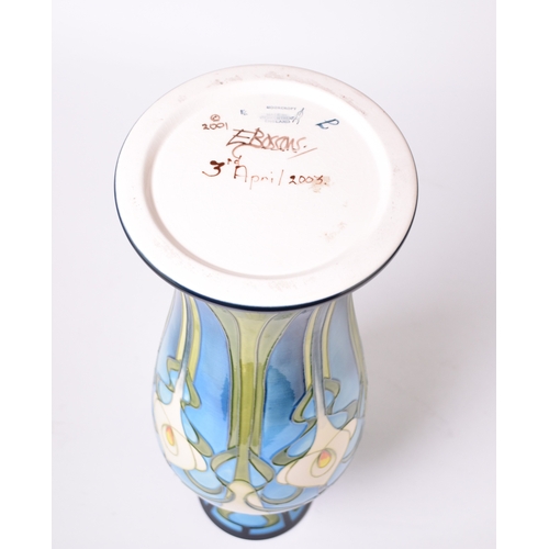 230 - A tall Moorcroft vase in the 'Calla Lily' pattern designed by Emma Bossons and dated 2003, signed by... 