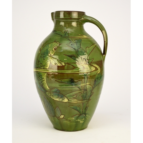 43 - A large C H Brannam Barum Pottery green-glazed jug, decorated by William Baron with a large single c... 