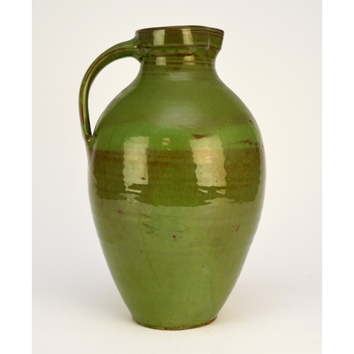 43 - A large C H Brannam Barum Pottery green-glazed jug, decorated by William Baron with a large single c... 