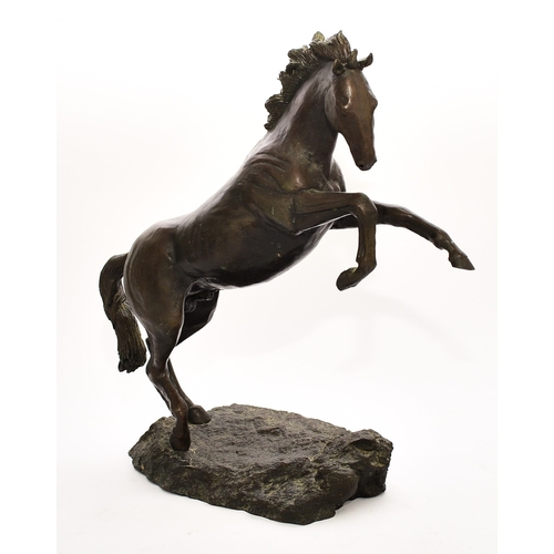 538 - A 20th century bronze figure of a horse The stallion modelled rearing up on its hind legs on a rocky... 