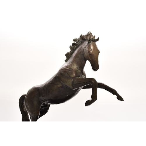 538 - A 20th century bronze figure of a horse The stallion modelled rearing up on its hind legs on a rocky... 