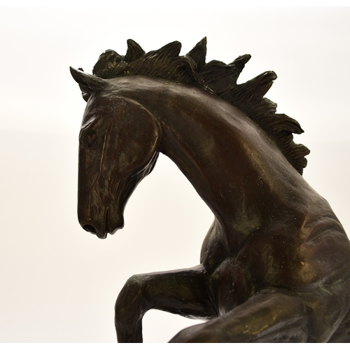 538 - A 20th century bronze figure of a horse The stallion modelled rearing up on its hind legs on a rocky... 