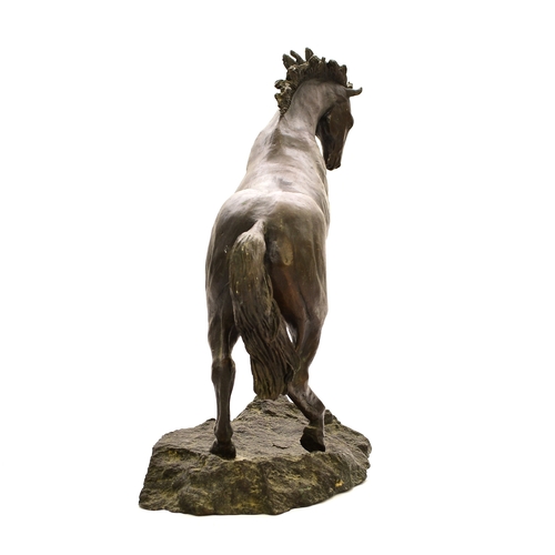 538 - A 20th century bronze figure of a horse The stallion modelled rearing up on its hind legs on a rocky... 