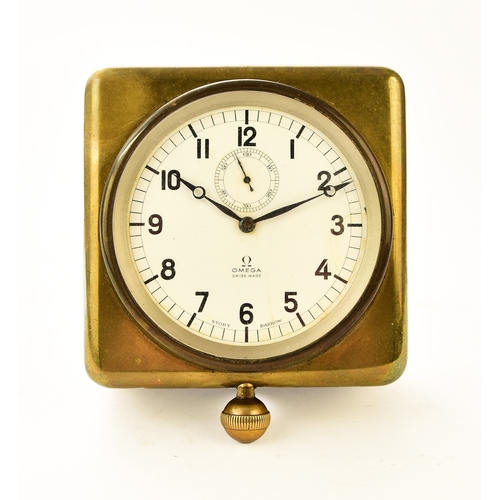 545 - An Omega brass-mounted car clock, retailed by Story of Barrow The white enamel dial with Arabic hour... 