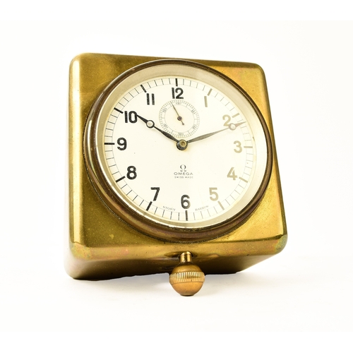 545 - An Omega brass-mounted car clock, retailed by Story of Barrow The white enamel dial with Arabic hour... 