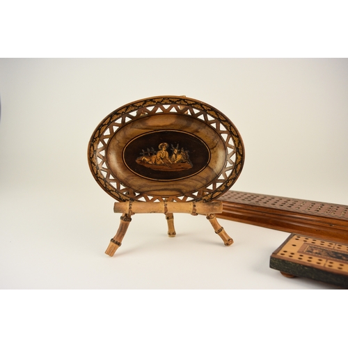 567 - An assembled group of treen To include: A pierced walnut marquetry oval dish, inlaid with a scene of... 