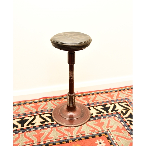 658 - A 20th century cast iron dentist stool on sprung leg Height adjustable with a swivel mechanism to th... 