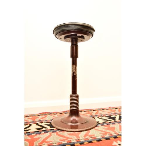 658 - A 20th century cast iron dentist stool on sprung leg Height adjustable with a swivel mechanism to th... 