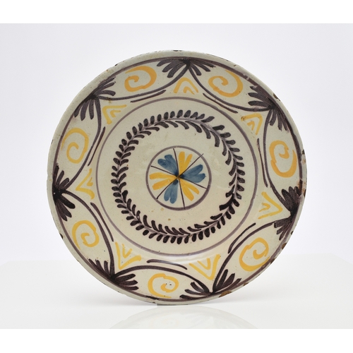 149 - An English delftware charger, 18th century, painted in polychrome with a building to the centre and ... 