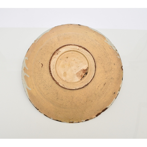 149 - An English delftware charger, 18th century, painted in polychrome with a building to the centre and ... 