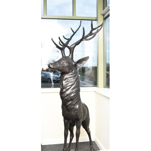 221 - A bronze garden statue of a stag Modern, modelled standing four square on a rocky outcrop. 200cm hig... 